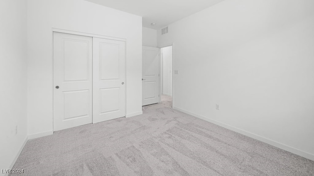 unfurnished bedroom featuring a closet, carpet flooring, baseboards, and visible vents
