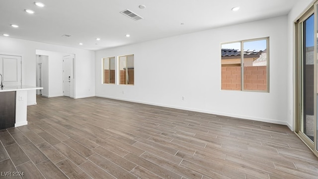 unfurnished living room featuring visible vents, wood finished floors, and recessed lighting