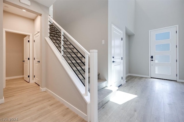 entrance foyer featuring light hardwood / wood-style flooring and a high ceiling