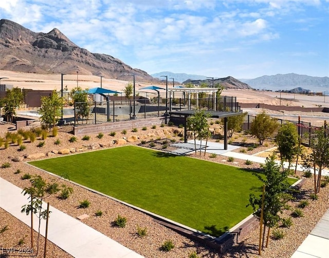 view of home's community with a mountain view, a pergola, and a lawn