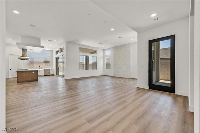 unfurnished living room featuring light hardwood / wood-style flooring and sink