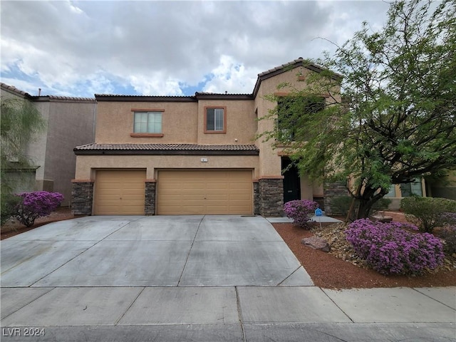 mediterranean / spanish-style house featuring stone siding, an attached garage, concrete driveway, and stucco siding