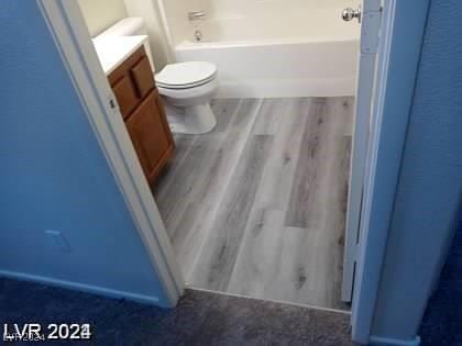 4085 Oliver Sagebrush Dr, Las Vegas, NV 89122 - bathroom featuring wood finished floors, vanity, toilet, and a tub