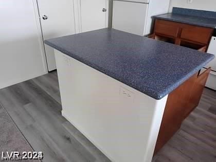 kitchen featuring hardwood / wood-style flooring, refrigerator, and a kitchen island