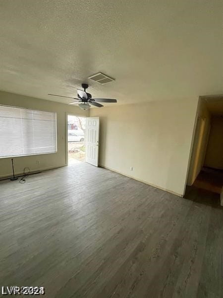 spare room featuring wood-type flooring, a textured ceiling, and ceiling fan