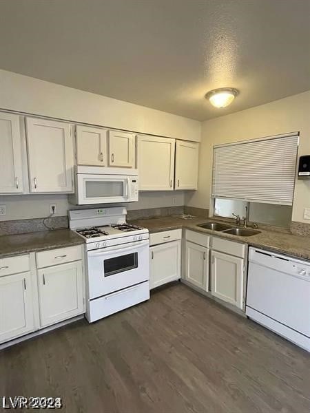 kitchen with dark wood-type flooring, white cabinets, sink, and white appliances