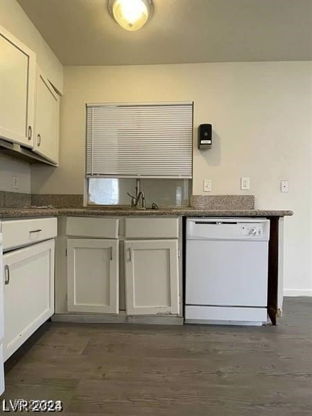 kitchen with white cabinets, dark hardwood / wood-style floors, white dishwasher, and dark stone countertops