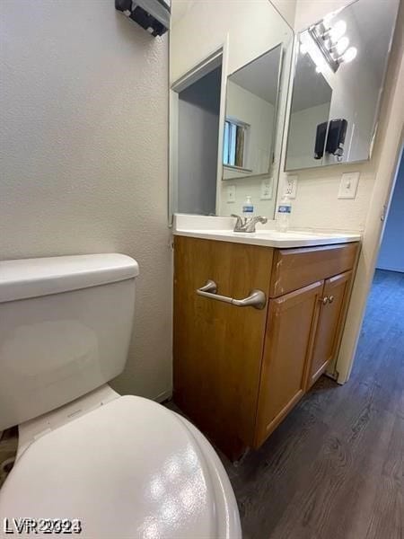 bathroom featuring hardwood / wood-style floors, toilet, and vanity