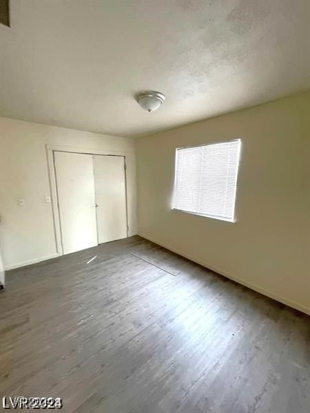 unfurnished bedroom featuring a closet and hardwood / wood-style flooring