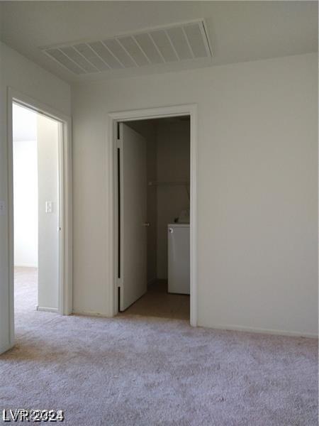 carpeted spare room featuring washer / clothes dryer