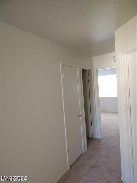 hallway featuring light carpet