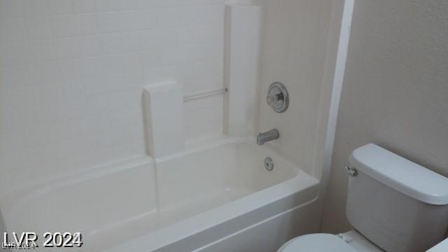 bathroom with bathtub / shower combination and toilet