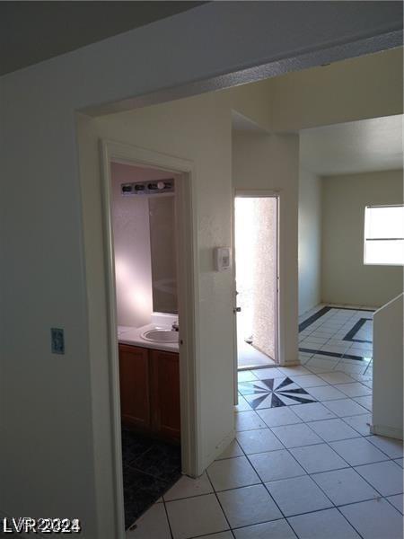 hall featuring sink, a wealth of natural light, and light tile patterned floors