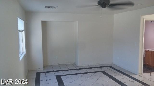 tiled empty room featuring ceiling fan