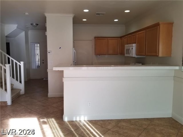 kitchen with white appliances, ornamental molding, kitchen peninsula, and light tile patterned flooring