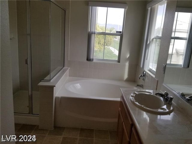 bathroom featuring tile patterned floors, vanity, and shower with separate bathtub