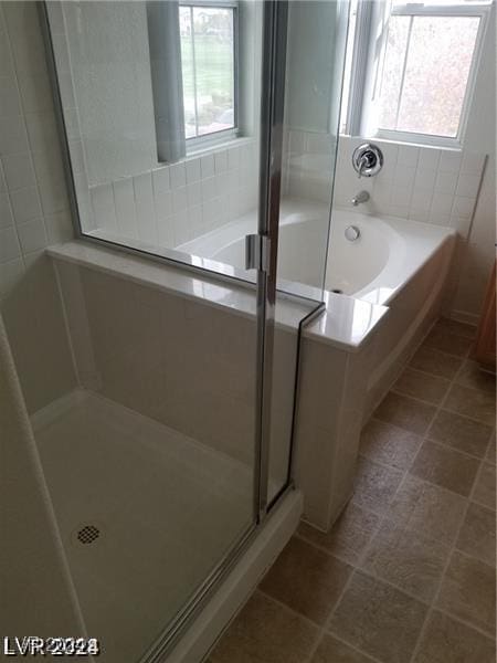 bathroom featuring separate shower and tub, a wealth of natural light, and tile patterned floors