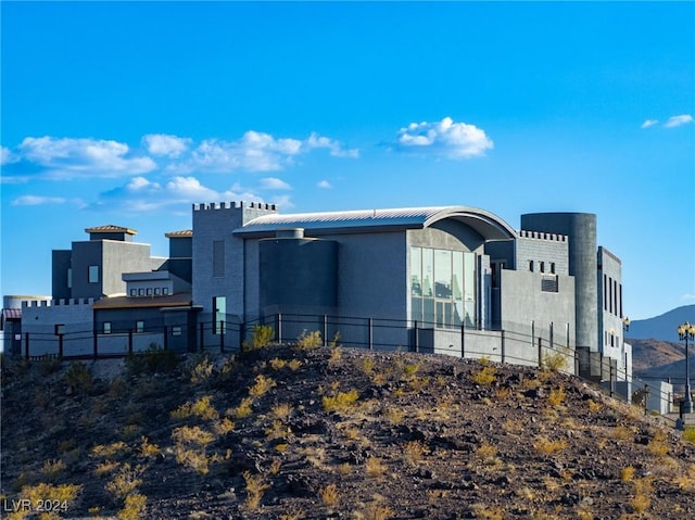 view of building exterior featuring fence and a mountain view