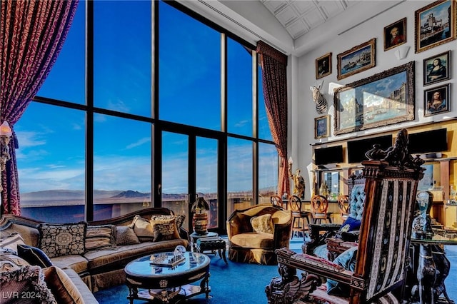 living room featuring a wall of windows, a wealth of natural light, and carpet flooring