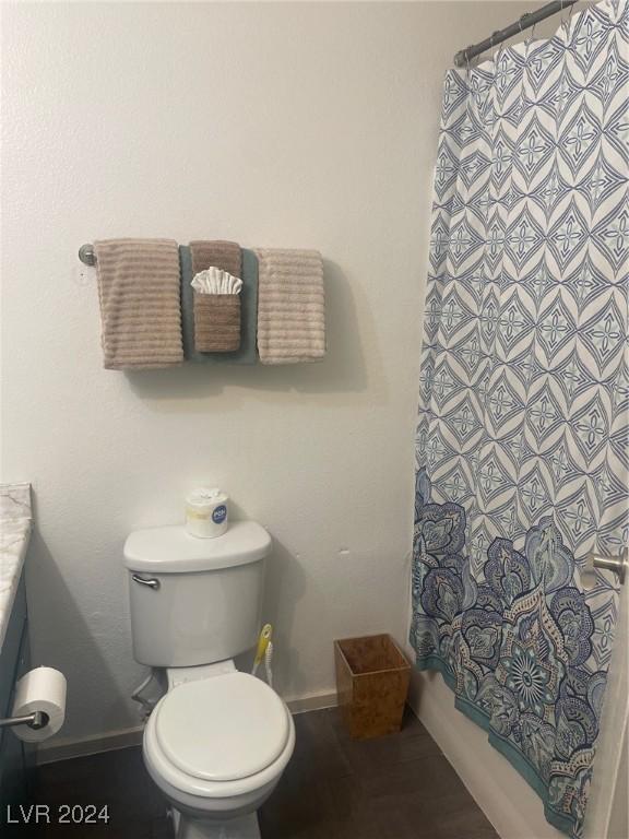 full bathroom featuring toilet, baseboards, and vanity