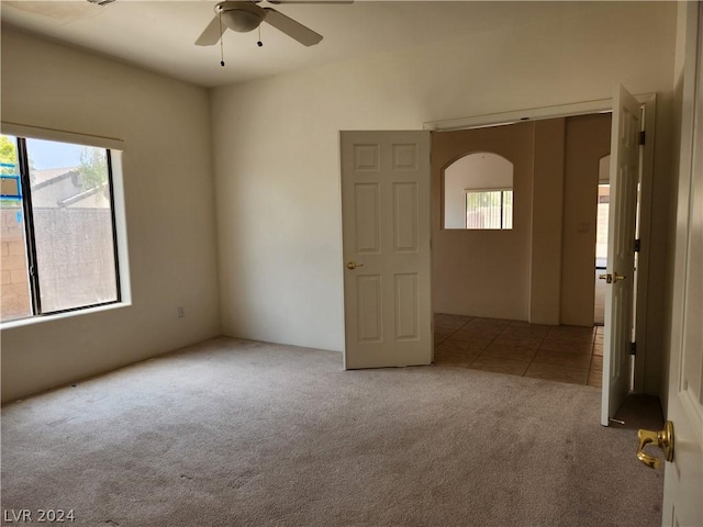 unfurnished room featuring plenty of natural light, light colored carpet, and ceiling fan