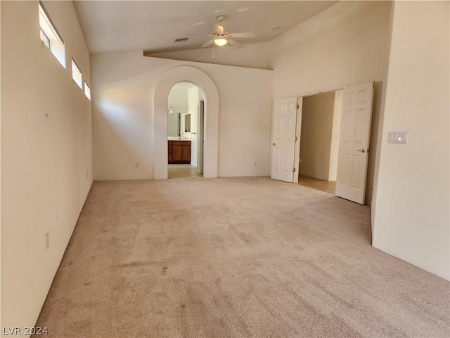 carpeted spare room with high vaulted ceiling and ceiling fan