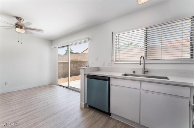 kitchen with sink, white cabinetry, light hardwood / wood-style flooring, stainless steel dishwasher, and ceiling fan