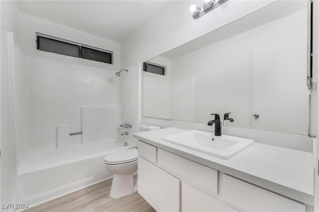 full bathroom with wood-type flooring, toilet,  shower combination, and vanity