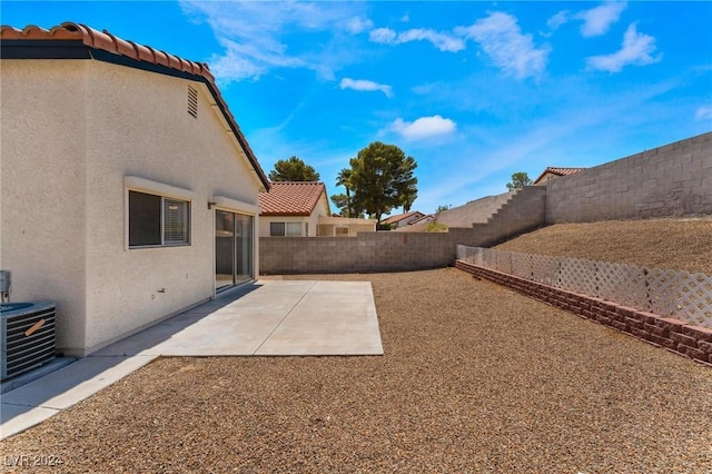 view of yard with central AC and a patio area