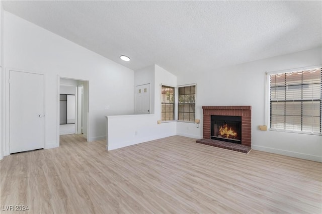 unfurnished living room featuring a healthy amount of sunlight, a textured ceiling, and light wood-type flooring