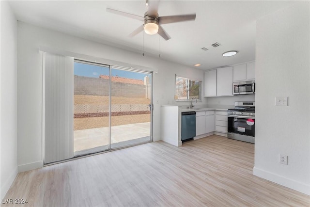 kitchen featuring white cabinetry, appliances with stainless steel finishes, ceiling fan, and light hardwood / wood-style flooring