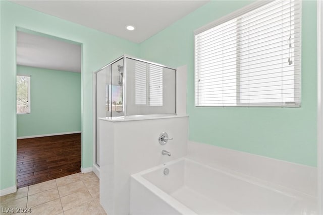 full bath featuring a stall shower, tile patterned flooring, and a bath