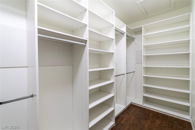 walk in closet featuring wood finished floors and attic access