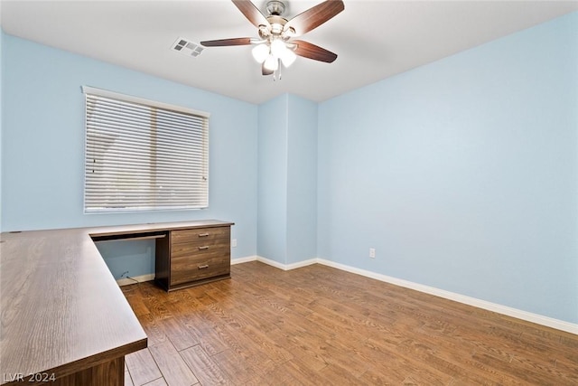 unfurnished office featuring light wood-style floors, visible vents, baseboards, and a ceiling fan