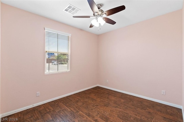 unfurnished room featuring dark wood-style floors, visible vents, ceiling fan, and baseboards