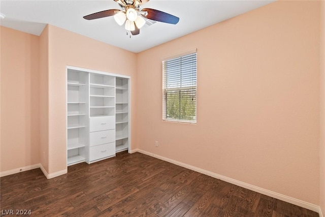 unfurnished bedroom with dark wood-style floors, a closet, ceiling fan, and baseboards