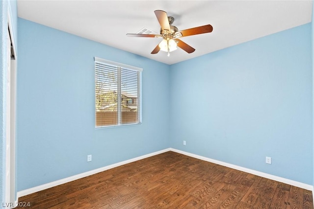 empty room with dark wood-style flooring, ceiling fan, and baseboards