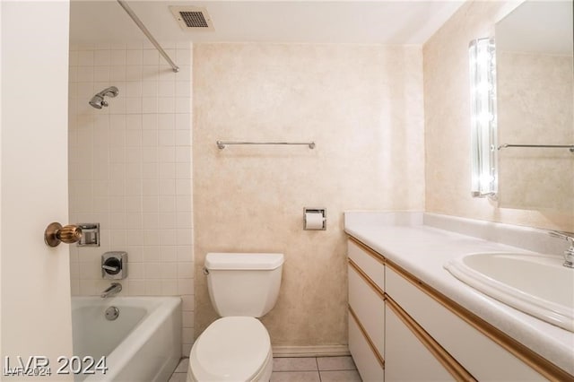 full bathroom featuring tiled shower / bath, vanity, toilet, and tile patterned floors