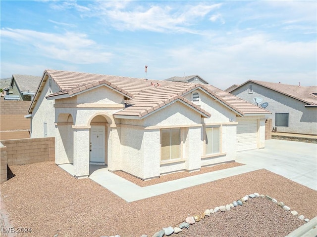 view of front of home featuring a garage, concrete driveway, a tiled roof, and stucco siding