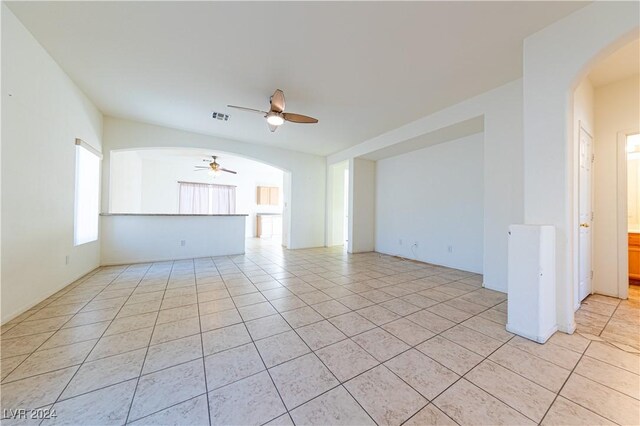 unfurnished living room with light tile patterned floors and ceiling fan