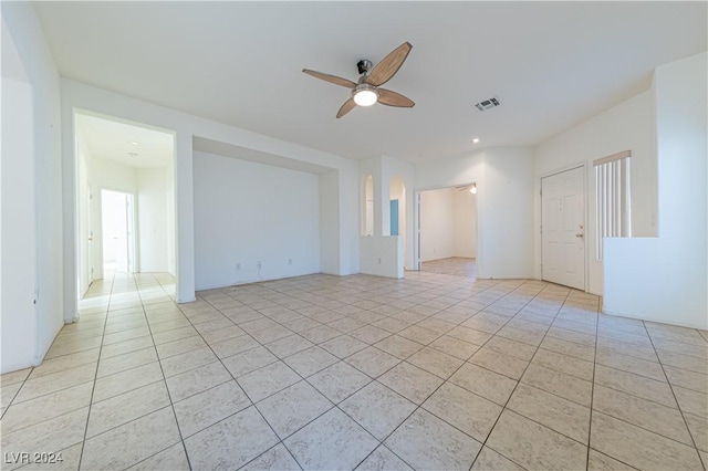 empty room featuring a ceiling fan, visible vents, and light tile patterned floors