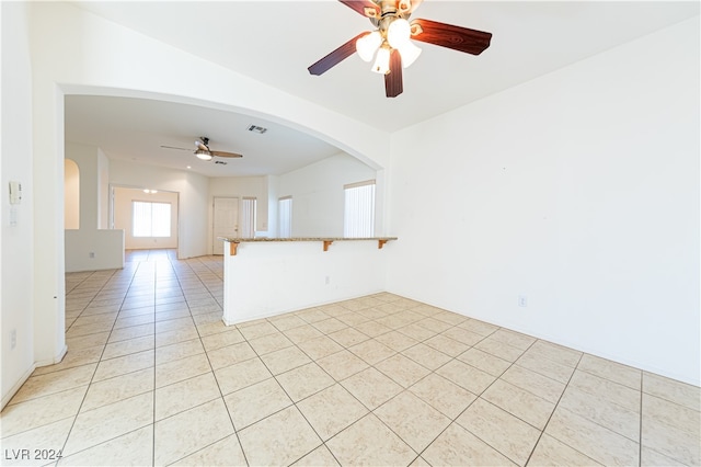 tiled spare room with ceiling fan