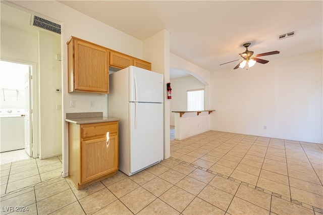 kitchen featuring light tile patterned flooring, washer / clothes dryer, white fridge, and ceiling fan