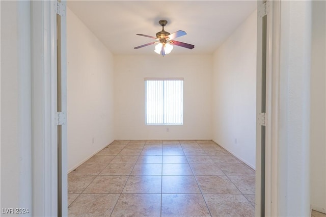 unfurnished room with a ceiling fan and light tile patterned floors