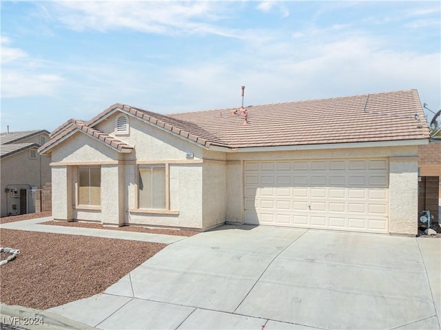 view of front of property with driveway, an attached garage, a tile roof, and stucco siding