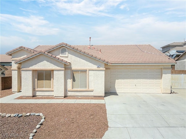 view of front of home with a garage, driveway, a tile roof, and stucco siding