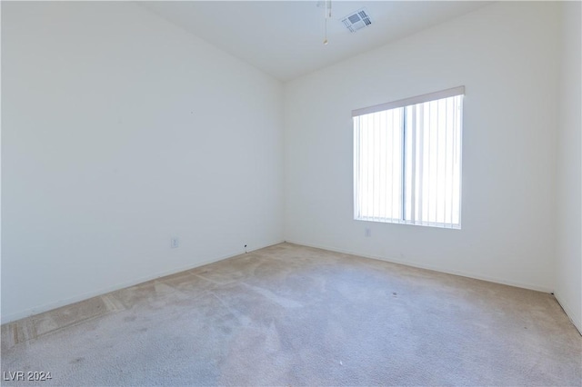 spare room featuring visible vents and light carpet