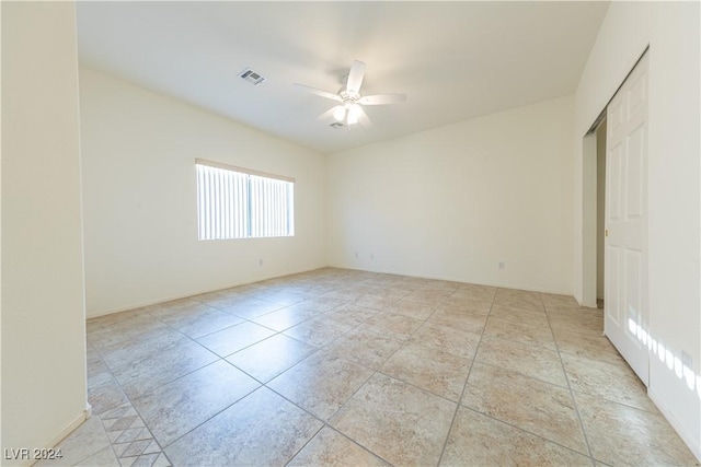 unfurnished room with ceiling fan, light tile patterned floors, and visible vents