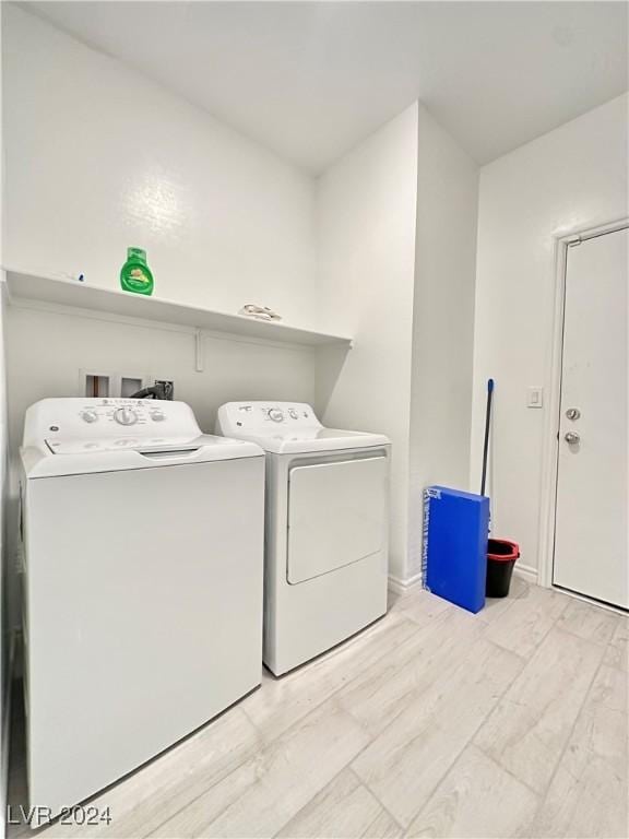 washroom with washer and clothes dryer and light hardwood / wood-style flooring