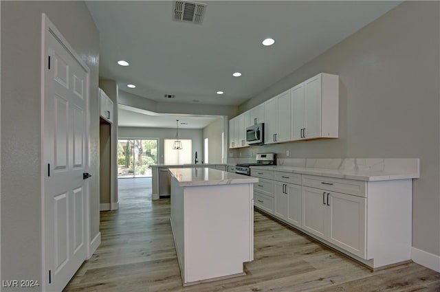 kitchen featuring appliances with stainless steel finishes, white cabinetry, and light countertops